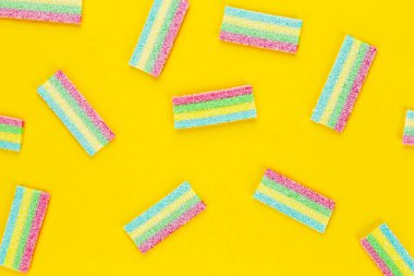 Meyan kökü şekeri. Sarı arka planda farklı aromalı tatlı jelibonlar. Üst görünüm.