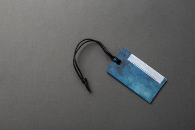 İple bağlanmış boş bir etiket. Fiyat etiketi, hediye etiketi, satış etiketi, gri arka planda izole edilmiş adres etiketi. Mesaj için yer var. Üst görünüm.