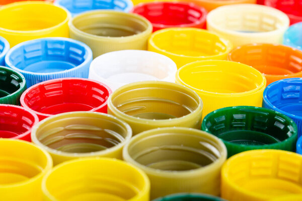 Пластиковые крышки бутылки фона. Материал кэпа подлежит переработке. Сбор и переработка пластиковых крышек для бутылок.