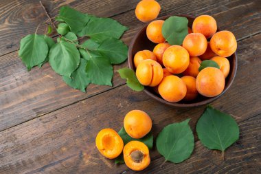 Masanın üzerindeki ahşap kasede lezzetli olgun kayısılar.. 