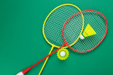 İki mekik horozu ve badminton raketi. Yeşil bir arka planda. Yaz tatili kavramı.