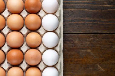 Tahta bir masada tepside tavuk yumurtası. Kahvaltı ürünleri konsepti. Üst Manzara. Metin için boşluk.