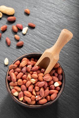 Siyah bir masada kabukta fıstık soyulmuş. Fıstık ezmesi ya da tereyağı yapmak için. Bira aperatifleri. Sağlıklı gıda konsepti. 