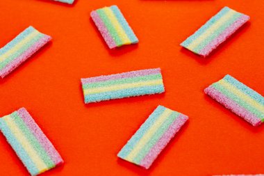 Meyan kökü şekeri. Kırmızı arka planda farklı aromalı tatlı jelibonlar. Üst görünüm.