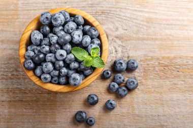 Tahta bir kasede taze toplanmış yabanmersini. Sağlıklı meyve, organik gıda, antioksidan, vitamin, mavi gıda..