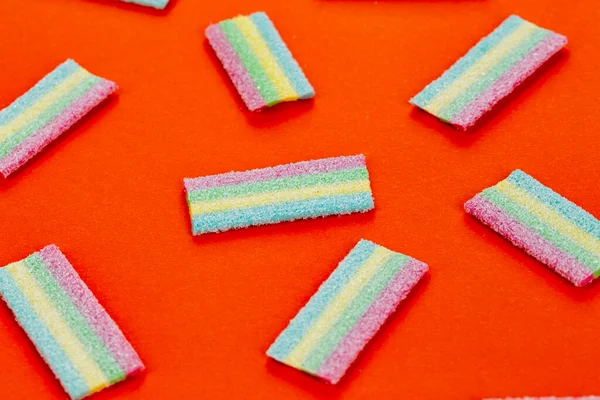 Meyan kökü şekeri. Kırmızı arka planda farklı aromalı tatlı jelibonlar. Üst görünüm.