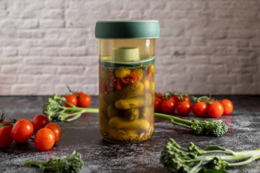 Ev yapımı mayalanmış turşu ve sebzeli bir basın kavanozunun geçmişe dönük yemek fotoğrafları. Eski görünümlü natürmort..