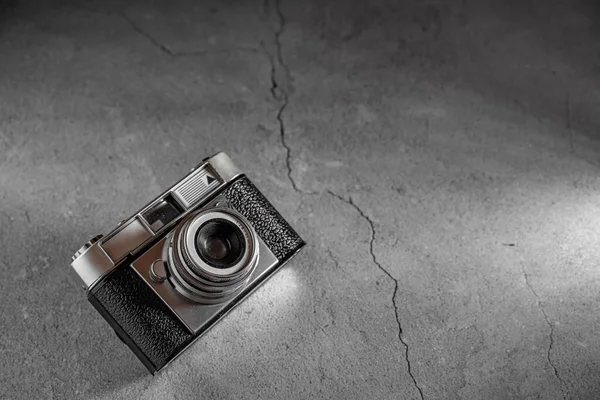 Flat lay of a old film retro camera with shallow depth of field on a stone background. Camera technology concept with a vintage look with copy space.