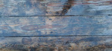 Parlak bir kaplaması olan eski gri ahşap kalasların doğal bir deseni vardır. Duvara dayalı ahşap tahıllar..