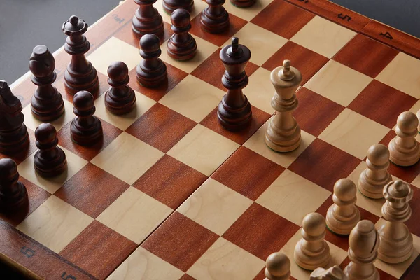 Classic Wooden Tournament chess set on black background. Two kings in centre of board other pieces lined up