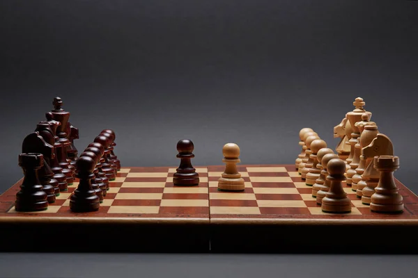 黒を基調としたクラシック木製のトーナメントチェス ボードの中央に2つの質屋が並んでいます — ストック写真