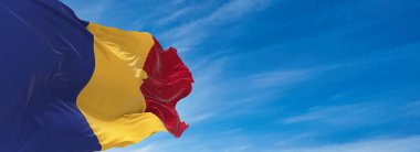 Romanya 'nın büyük bayrağı güneşli bir günde bulutlarla rüzgarda sallanıyor. 3d illüstrasyon