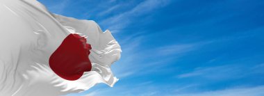 Güneşli bir günde gökyüzüne karşı rüzgarda dalgalanan büyük Japon bayrağı. 3d illüstrasyon