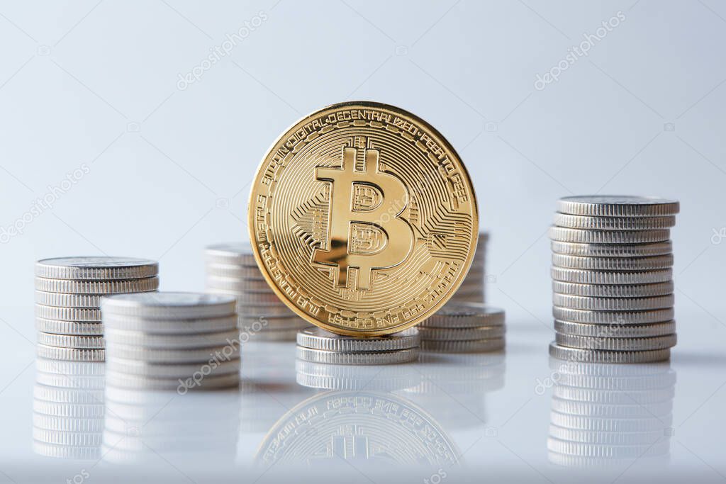Golden and shiny bitcoin coins on top of various world currencies representing a choice of different payment and investment options.