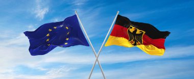 Avrupa Birliği ve Almanya 'nın bayrakları güneşli bir günde gökyüzüne doğru bayrak direkleri sallıyor. İki ülke arasındaki ilişkiyi, diyaloğu sembolize ediyor. 3d illüstrasyon,