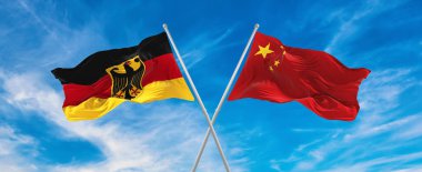 Çin ve Almanya 'nın bayrakları rüzgarda dalgalanırken bayrak direkleri gökyüzüne karşı güneşli bir günde bulutlarla. İki ülke arasındaki ilişkiyi, diyaloğu sembolize ediyor. 3d illüstrasyon,