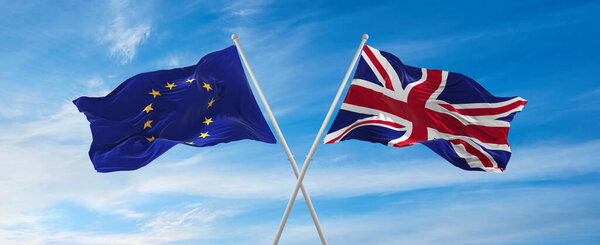 флаги Европейского Союза и Великобритании, машущие на ветру на флагштоках против неба с облаками в солнечный день. Символизирующие отношения, диалог между двумя странами. 3d иллюстрация,