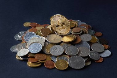 Çeşitli dünya para birimlerinin üzerinde altın ve parlak bitcoin paralar farklı ödeme ve yatırım seçeneklerini temsil eder.