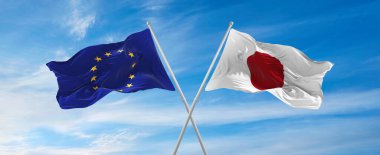 Avrupa Birliği bayrakları ve Japonya 'nın bayrak direkleri rüzgarda dalgalanırken güneşli bir günde bulutlarla gökyüzüne karşı. İki ülke arasındaki ilişkiyi, diyaloğu sembolize ediyor. 3d illüstrasyon,