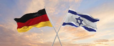 flags of Germany and Israel waving in the wind on flagpoles against sky with clouds on sunny day. Symbolizing relationship, dialog between two countries. 3d illustration,