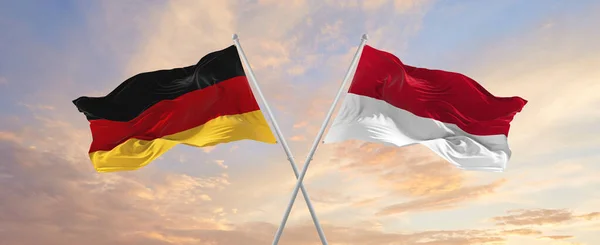 Flaggor Tyskland Och Indonesien Vinka Vinden Flaggstänger Mot Himlen Med — Stockfoto