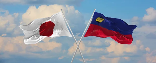 Прапори Японії Ліхтенштейну Махають Вітром Флагштоках Проти Неба Хмарами Сонячний — стокове фото