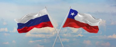 flags of Russia and Chile waving in the wind on flagpoles against sky with clouds on sunny day. Symbolizing relationship, dialog between two countries. 3d illustration,