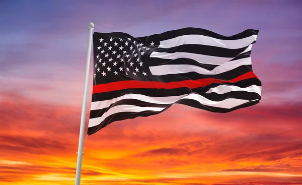 Thin Red Line. Black Flag of USA with Firefighter red Line waving in the wind on flagpole against the sky with clouds on sunny day. 3d illustraion.