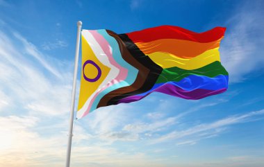 LGBTQ İlerleme Gururu cinsiyetler arası kapsama bayrağı bulutlu gökyüzünde rüzgarda dalgalanıyor. Özgürlük ve aşk kavramı. Gurur ayı. Eylemcilik, toplum ve özgürlük kavramı. Uzayı kopyala 3d illüstrasyon.