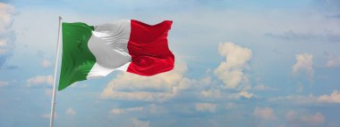 İtalya bayrağı bulutlu gökyüzü arka planında, günbatımında, panoramik manzara. İtalya hakkında vatansever bir kavram ve geniş afiş için kopyalama alanı. 3d illüstrasyon,