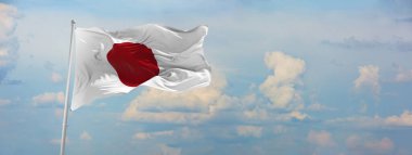 Japonya bayrağı bulutlu gökyüzü arka planında, günbatımında, panoramik manzara. Japonlar hakkında vatansever bir kavram ve geniş afişler için kopyalama alanı. 3d illüstrasyon,