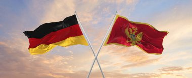 Almanya ve Karadağ 'ın bayrakları rüzgarda dalgalanırken güneşli bir günde gökyüzüne doğru bayrak direkleri sallanıyor. İki ülke arasındaki ilişkiyi, diyaloğu sembolize ediyor. 3d illüstrasyon,