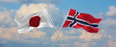 Japonya ve Norveç 'in bayrak direkleri rüzgarda dalgalanırken güneşli bir günde gökyüzüne karşı bulutlar. İki ülke arasındaki ilişkiyi, diyaloğu sembolize ediyor. 3d illüstrasyon,