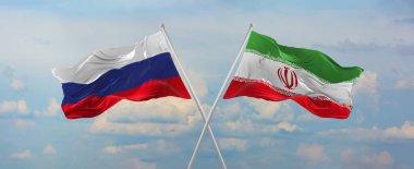 Rusya ve İran 'ın bayrakları rüzgarda dalgalanırken bayrak direkleri gökyüzüne karşı güneşli bir günde bulutlarla. İki ülke arasındaki ilişkiyi, diyaloğu sembolize ediyor. 3d illüstrasyon,