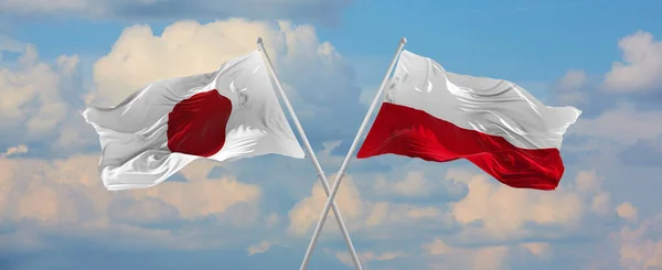 Japonya Polonya Bayrakları Rüzgarda Dalgalanırken Bayrak Direkleri Gökyüzüne Karşı Güneşli — Stok fotoğraf