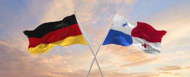 Almanya ve Panama 'nın bayrakları rüzgarda dalgalanırken bayrak direkleri gökyüzüne karşı güneşli bir günde bulutlarla. İki ülke arasındaki ilişkiyi, diyaloğu sembolize ediyor. 3d illüstrasyon,