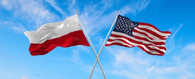 ABD ve Polonya bayrakları rüzgarda dalgalanırken bayrak direkleri gökyüzüne karşı güneşli bir günde bulutlarla. İki ülke arasındaki ilişkiyi, diyaloğu sembolize ediyor. 3d illüstrasyon,