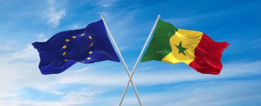 flags of European Union and Senegal waving in the wind on flagpoles against sky with clouds on sunny day. Symbolizing relationship, dialog between two countries. 3d illustration,