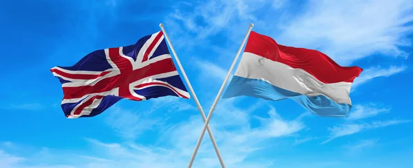 晴れた日には雲と空に向かって旗竿で風になびく英国とルクセンブルクの旗 関係を象徴し 両国間の対話 3Dイラスト — ストック写真