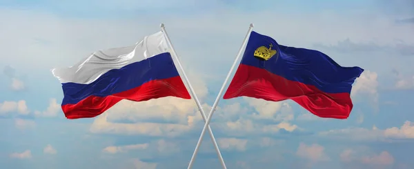 러시아와 리히텐슈타인의 국기가 위에서 하늘을 바람에 흔들리고 관계를 상징하고 나라간의 — 스톡 사진