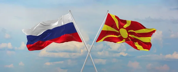 ロシアとマケドニアの旗は 晴れた日に雲と空に対して旗竿に風に振っています 関係を象徴し 両国間の対話 3Dイラスト — ストック写真