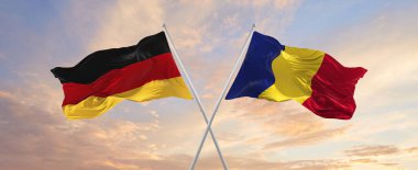 Almanya ve Romanya 'nın bayrakları rüzgarda dalgalanırken bayrak direkleri gökyüzüne karşı güneşli bir günde. İki ülke arasındaki ilişkiyi, diyaloğu sembolize ediyor. 3d illüstrasyon,