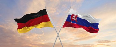 Almanya ve Slovakya 'nın bayrakları rüzgarda dalgalanırken bayrak direkleri gökyüzüne karşı güneşli bir günde bulutlarla. İki ülke arasındaki ilişkiyi, diyaloğu sembolize ediyor. 3d illüstrasyon,