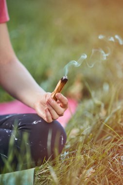 Genç sarışın kadın Yogini akşam, gün batımında parkta yoga egzersizi yapıyor. Yoga meditasyon ve sağlıklı spor konseptidir..