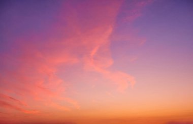 Bulutlu akşam gökyüzü manzarası. Günbatımı gökyüzü arkaplanı, aydınlık bulutlu gündoğumu gökyüzü. Güzel akşam gündoğumu denizin üstünde