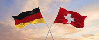 Almanya bayrakları ve rüzgarda dalgalanan bayrak direkleri güneşli bir günde gökyüzüne karşı. İki ülke arasındaki ilişkiyi, diyaloğu sembolize ediyor. 3d illüstrasyon,