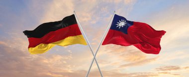 Almanya ve Tayvan bayrakları rüzgarda dalgalanırken bayrak direkleri gökyüzüne karşı güneşli bir günde. İki ülke arasındaki ilişkiyi, diyaloğu sembolize ediyor. 3d illüstrasyon,
