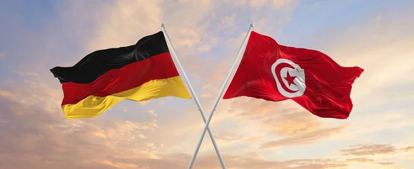 Flaggor Tyskland Och Tunisien Vinka Vinden Flaggstänger Mot Himlen Med — Stockfoto