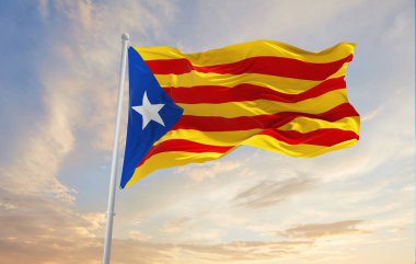 Estelada blava 'nın bayrakları rüzgarda dalgalanırken bayrak direkleri üzerinde güneşli bir günde gün batımı bulutlarıyla gökyüzüne karşı. Vatanseverliği simgeliyor. 3d illüstrasyon,