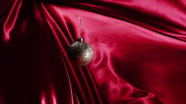 Gouden Fonkelende Bauble Red Silk Een Gouden Fonkelende Bauble Glijdt — Stockvideo